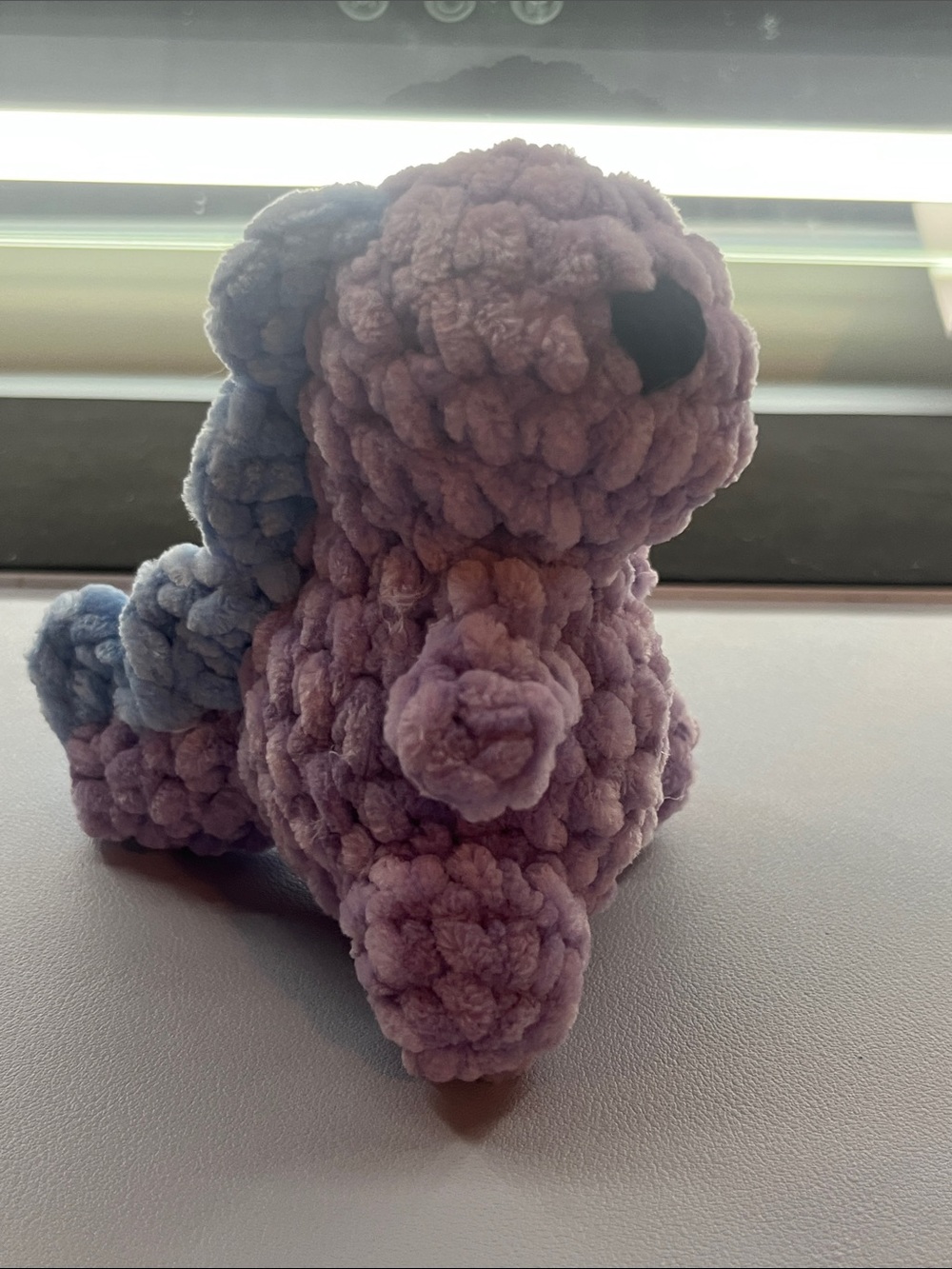 Crocheted purple dinosaur
